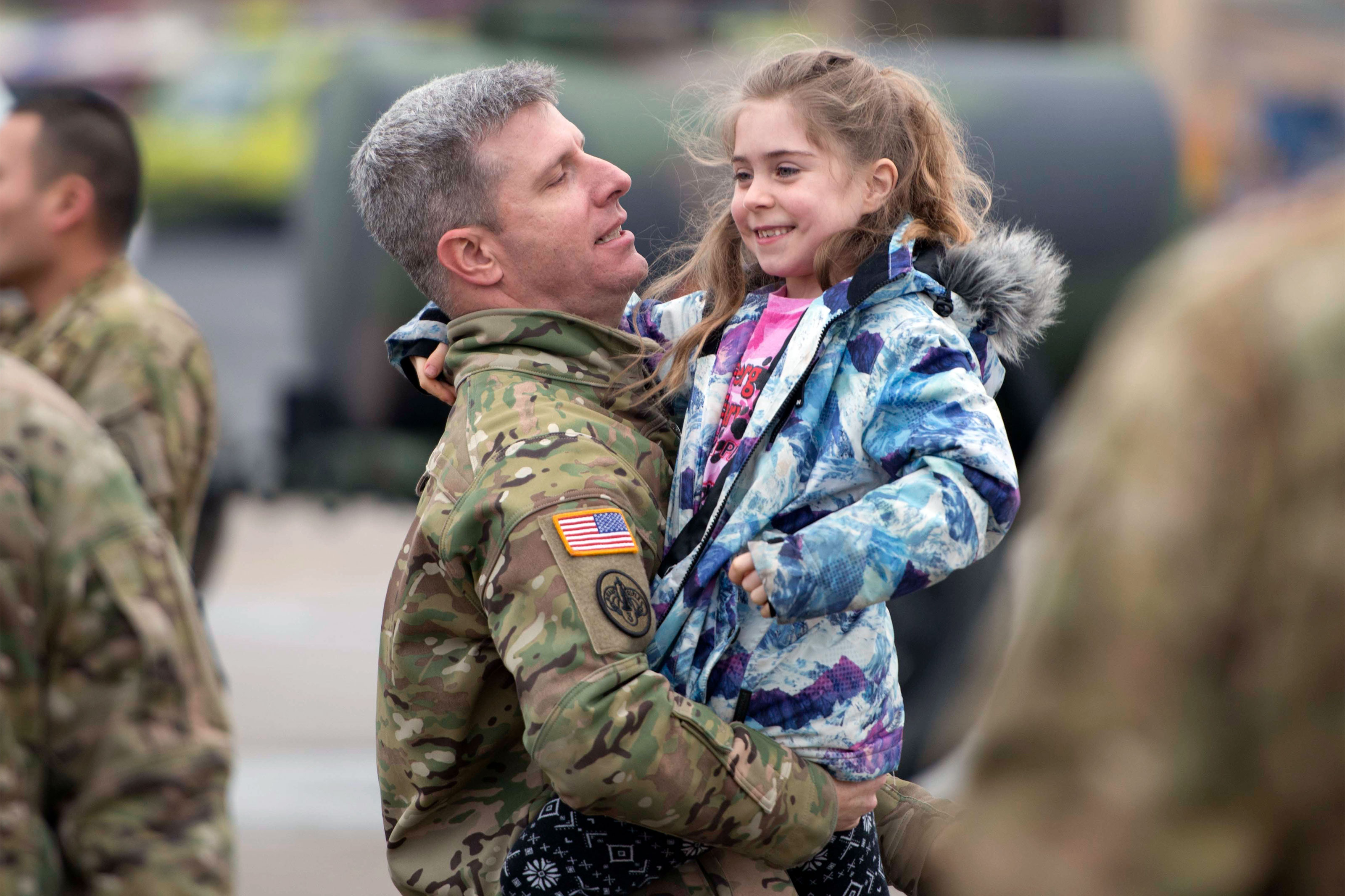 CW3 Erik Herr carries his excited daughter on the annual 1-214th GSAB on their annual &quot;Family Safety Day&quot;. (U.S. Army/Paul Hughes)