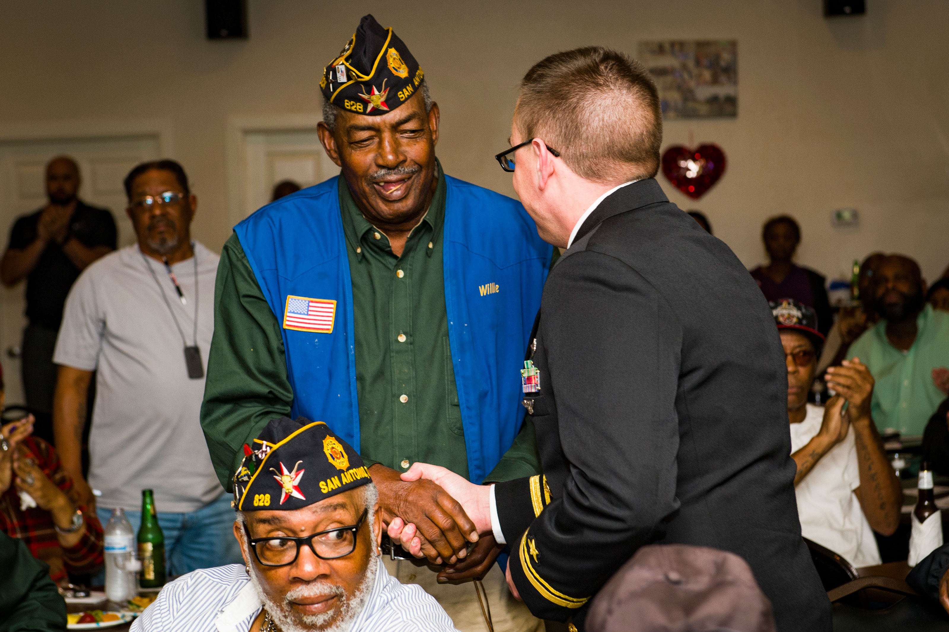 Lt. j.g. Mack Jamieson gives a pin to an American Legion Fred Brock Post No. 828 Vietnam war veteran as part of San Antonio Navy Week. (U.S. Navy/Specialist 3rd Class Casey J. Hopkins)