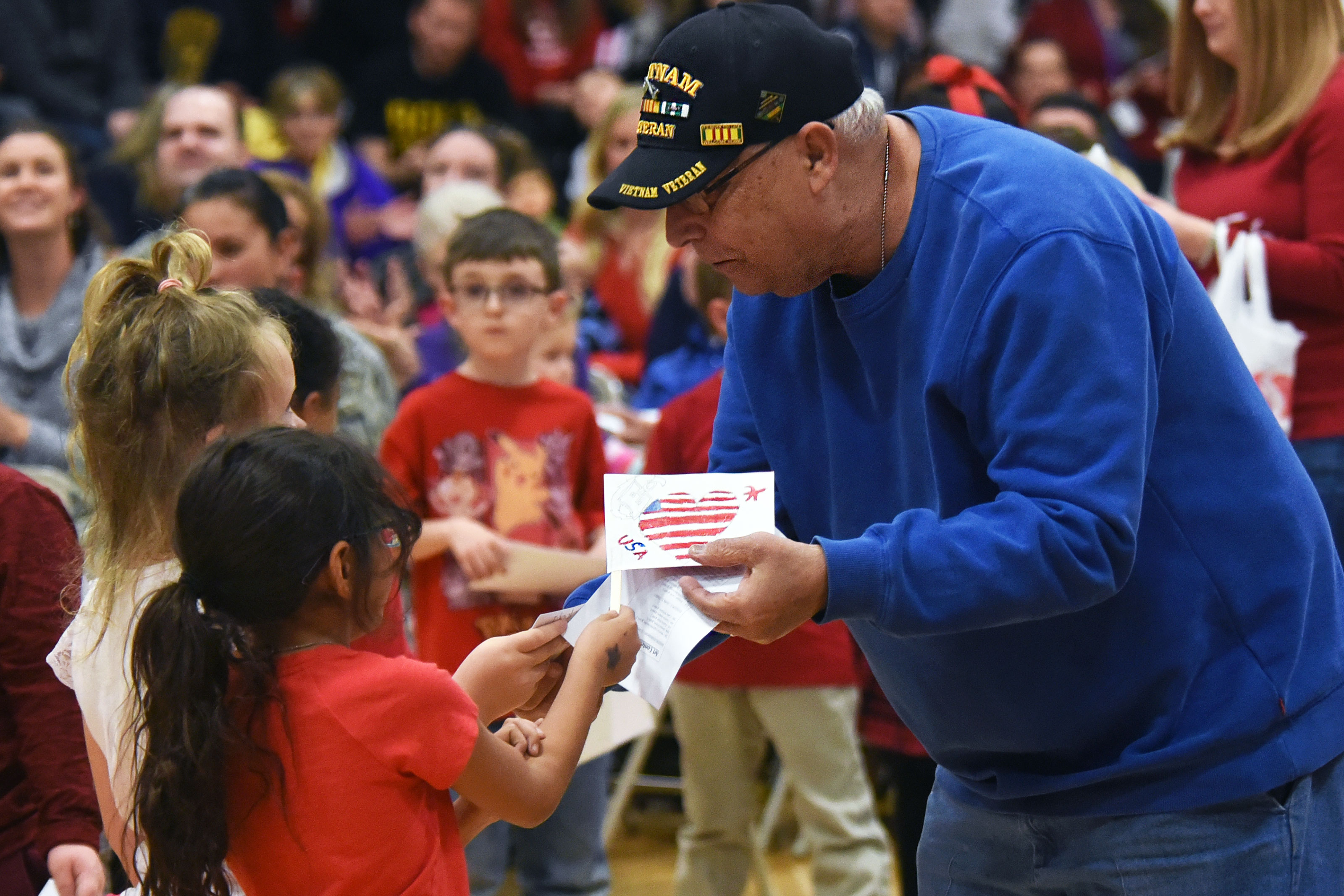 Ellicott students give thank you letters and hand-made flags to a Vietnam veteran during the Ellicott School District Veteran’s Day ceremony at Ellicott, Colorado. The Ellicott community event honored veterans, both past and present. (U.S. Air Force/William Tracy)