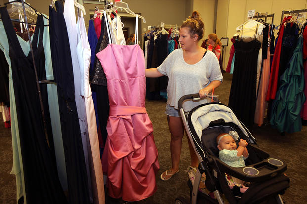 woman pushing stroller selecting ball gown