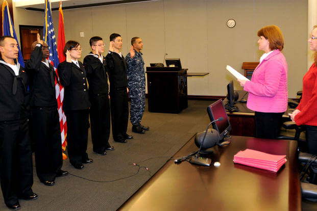 The first Navy sailors to participate in the MAVNI program are issued the oath of citizenship by Stacey Summers, branch chief from the U.S. Citizenship and Immigration Services Chicago field office. (US Navy photo/Scott Thornbloom)