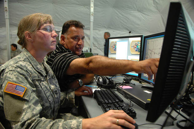 Capt. Eva Kelly, 38th Sustainment Brigade, receives instruction from Tony Torres on a tactical battle command system in a tactical operation center setup at Grissom Air Reserve Base, Indiana. (U.S. Army/William E. Henry) 
