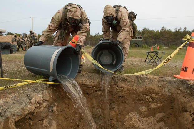 Soldiers with the Massachusetts Army National Guard, dispose of clean water used to clean notionally contaminated equipment on Joint Base Cape Code. The June, 2018 training was part of a Combined Arms Exercise which tests the mission readiness of combat support. (Massachusetts Army National Guard/Cody Kilduff)