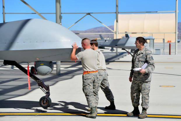 Tech. Sgt. Remington, a 432nd Maintenance Group quality assurance inspector, watches as a 432nd Aircraft Maintenance Squadron Tiger Aircraft Maintenance Unit team checks the weight and balance of an MQ-1 Predator on May 3, 2016, at Creech Air Force Base, Nev. (U.S. Air Force photo/Christian Clausen)