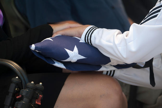 Danielle Myers, the great niece of U.S. Navy Machinist's Mate 1st Class Arthur Glenn, receives an American flag during a funeral at the National Memorial Cemetery of the Pacific, Honolulu, Hawaii, Aug. 21, 2018. On Dec. 7, 1941, Glenn was assigned to the USS Oklahoma which sustained fire from Japanese aircraft. (U.S. Navy/Seth Coulter)