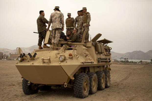 U.S. Marines and Peruvian naval infantrymen stand atop a Peruvian amphibious assault vehicle on Oct. 24, 2018, discussing mounted weapons handling. (US Marine Corps photo/ Frans E. Labranche)