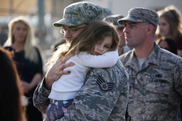 A child hugs a soldier goodbye before deployment