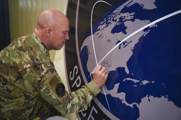 General John Raymond, U.S. Space Force chief of space operations, signs the United States Space Command sign inside of the Perimeter Acquisition Radar building Jan. 10, 2020, on Cavalier Air Force Station, North Dakota. (U.S. Air Force/Senior Airman Melody Howley)