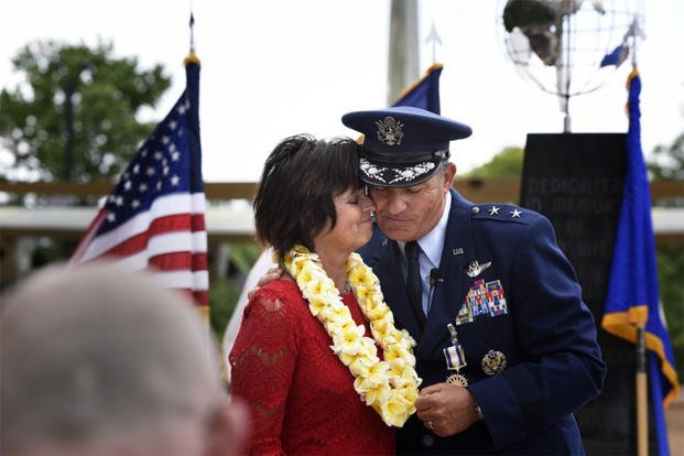 A military spouse and her husband embrace at a retirement ceremony.