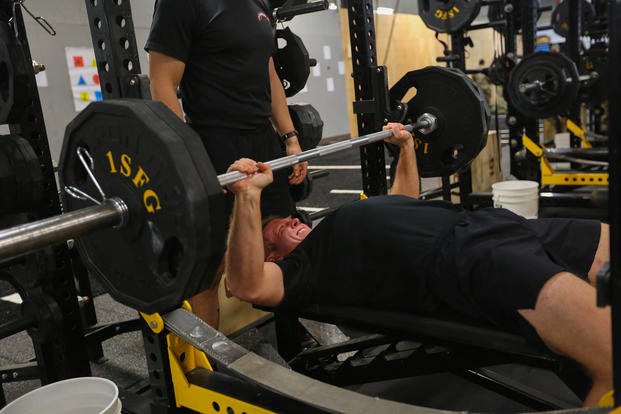 A soldier competes in a bench press competition.