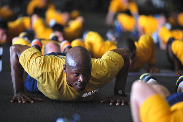 Navy petty officer performs push-ups.