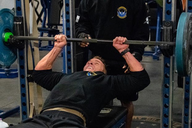 A Special Tactics airman performs on the bench press.