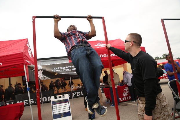 Marine recruiters conduct a pull-up challenge.