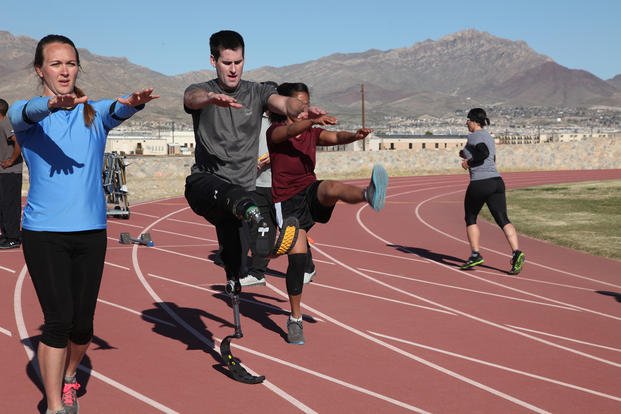 Soldiers and veterans perform dynamic stretches.