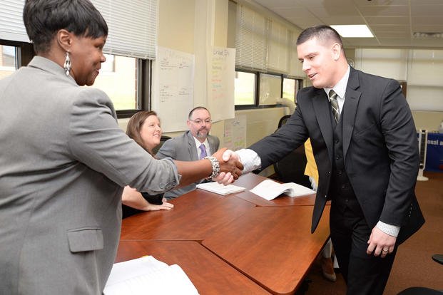 A professional interview panel quizzes transitioning service members in mock job-readiness interviews.