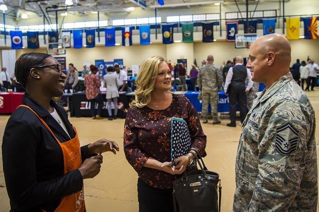 Brittany Moore, left, senior recruiter for a local hardware company, speaks to Senior Master Sgt. Jeremy Carlock, 23d Maintenance Group self-assessment program superintendent, right, and his wife, Shana, during a veterans career fair at Moody Air Force Base, Georgia. 