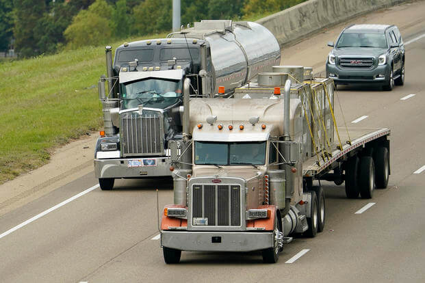 Long-haul truckers transport fuel and heavy-duty equipment on Interstate 55 in Jackson, Miss.
