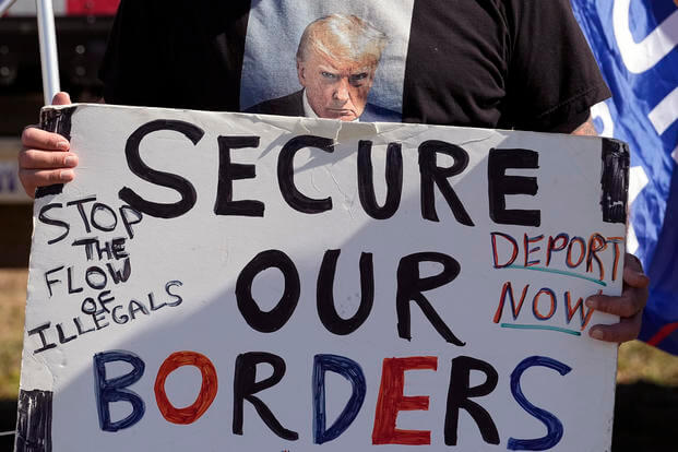 Phill Cady holds a sign during a "Take Our Border Back" rally