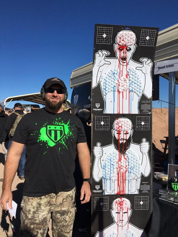 Jared Ogden, a former NAVY SEAL who recently launched his own business, Triumph Systems, on Jan. 16, 2017, during range day outside Las Vegas at SHOT Show stands near one of his products called Threat Down, a zombie or humanoid target with vital areas covered in plastic hexagonal packs containing brightly colored biodegradable gel that bleed when shot. (Military.com photo)