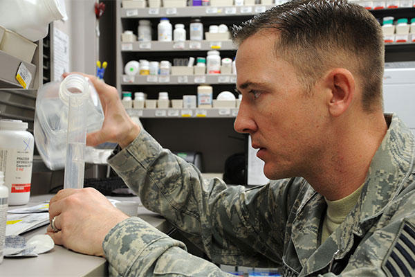 An Air Force pharmacy technician measures distilled water for medicine. (U.S. Air Force photo/Staff Sgt. Julius Delos Reyes)