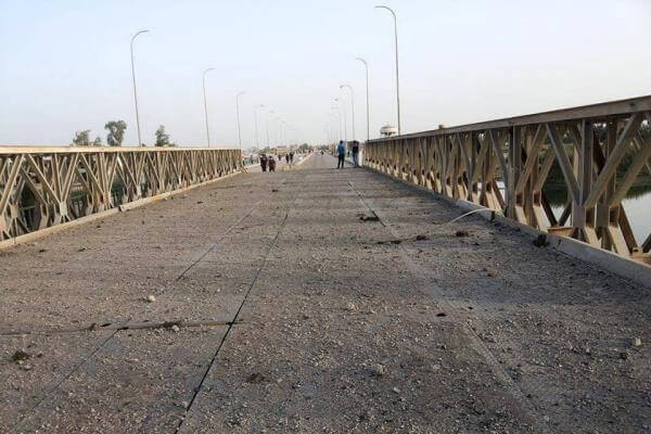 People visit a destroyed bridge on the Euphrates river in northern Ramadi, Iraq, on June 3, 2015. (AP photo)