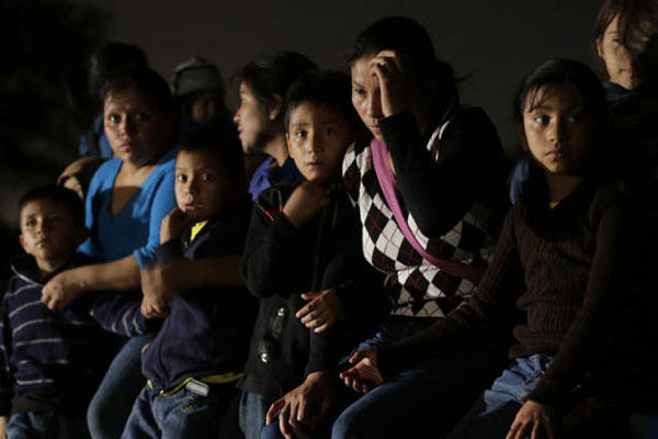 FILE - In this June 25, 2014 photo shows a group of immigrants from Honduras and El Salvador who crossed the U.S.-Mexico border illegally are stopped in Granjeno, Texas. (AP Photo/Eric Gay, File)