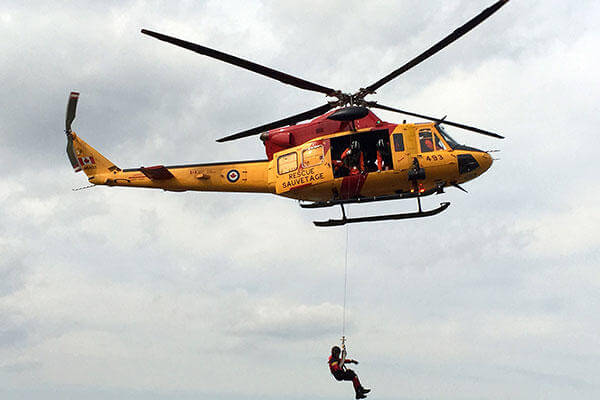 A Royal Canadian Air Force CH-146 Griffon helicopter conducts hoist evolutions during joint training operations with the U.S. Coast Guard in Barrie, Ontario, May 5, 2015. (U.S. Coast Guard photo)