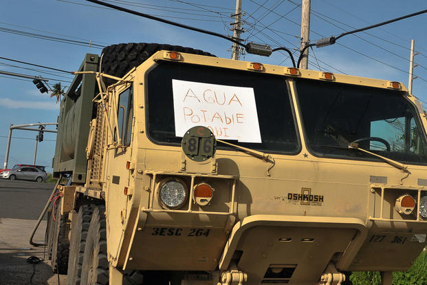 A M977 Heavy Expanded Mobility Tactical Truck with 2,000 gallons of purified water from the Rosy Roads water station in Puerto Rico displays an “Agua Potable Aqui” (Potable Water Here) sign in the window, Oct. 14, 2017. (U.S. Army/Sgt. Michael Eaddy)