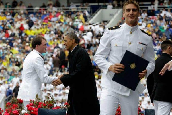 President Barack Obama congratulates a graduate as another one celebrates at the United States Naval Academy graduation ceremony in Annapolis, Md., Friday, May 24, 2013. (AP Photo/Pablo Martinez Monsivais)