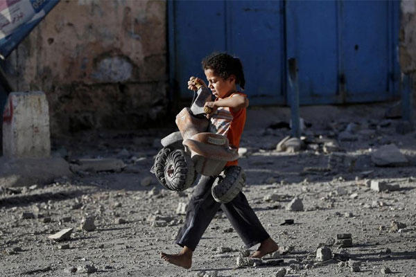 A Palestinian girl walks with a toy that she salvaged from debris of the el-Yazje apartment building which was destroyed following an overnight Israeli missile strike in Gaza City, Thursday, July 17, 2014. (AP photo)