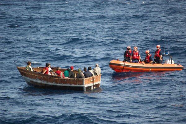 In this Dec. 30, 2014, photo provided by the U.S. Coast Guard, members of the U.S. Coast Guard Cutter Knight Island approach a boat with 12 Cuban migrants southwest of Key West, Fla. (AP Photo/U.S. Coast Guard)