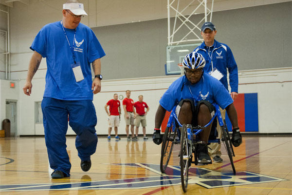 Air Force Tech. Sgt. Ryan Delaney, left, a wounded warrior mentor, watches Tremayne Maxwell, an Air Force wounded warrior athlete, perfect his wheelchair basketball skills at Eglin Air Force Base, April 13, 2015. U.S. Air Force photo/Samuel King Jr.  