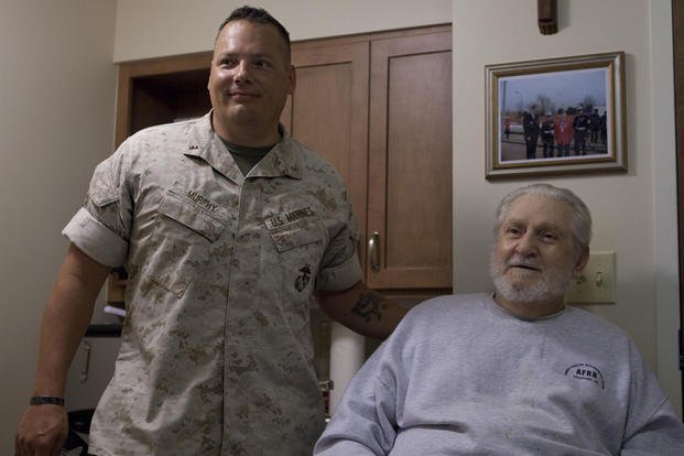 CWO 4 Jerod Murphy, assistant ordnance officer for 1st Marine Division, and John Morash Sr., a retired Marine, pose together at the Armed Forces Retirement Home in Gulfport, Miss., August 12, 2015. (Photo By: Sgt. Melissa Karnath)