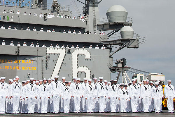 Sailors stand in formation on the flight deck of the Nimitz-class aircraft carrier USS Ronald Reagan before departing Naval Base Coronado. (U.S. Navy/MC 3rd Class Nathan Burke)