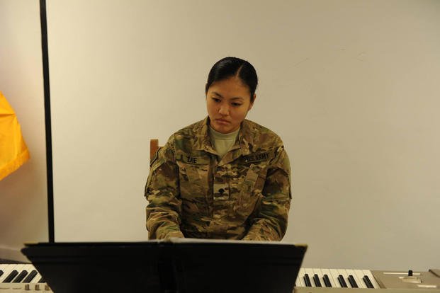 Army Spc. Anne Lee plays the piano during an event on Bagram Airfield in Afghanistan. (Photo: Kevin Walston)