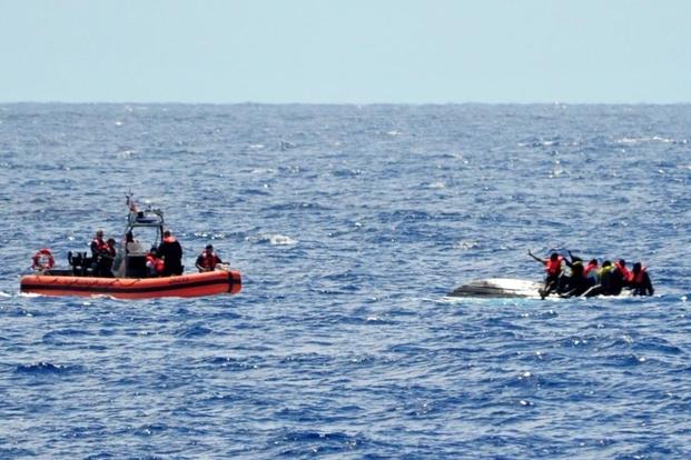 A small boat crew from the U.S. Coast Guard Cutter Bernard Webber approaches 10 people on top of an overturned vessel April 9, 2016. (Photo: U.S. Coast Guard)
