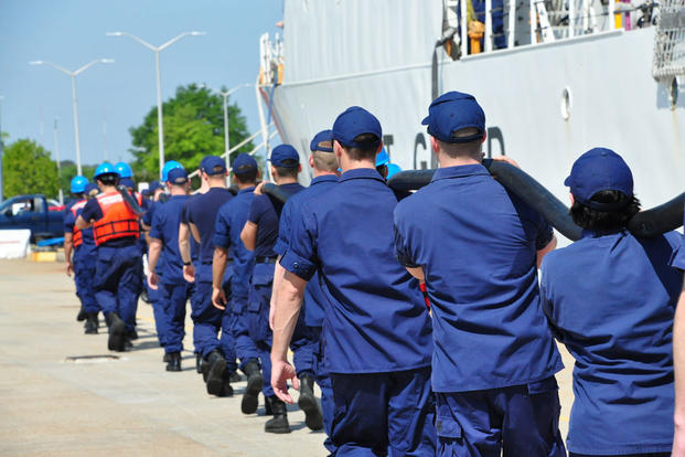 Coast Guard Cutter Tampa crew members carry a shore power cable on the pier at Base Portsmouth, Virginia, April 27, 2016. (Photo: Petty Officer 1st Class Melissa Leake)