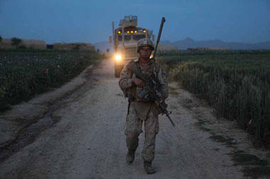 An infantryman with 3rd Battalion, 4th Marines, escorts a combat vehicle full of supplies for an observation post in Helmand province, Afghanistan. Cpl. Marco Mancha/Marine Corps 