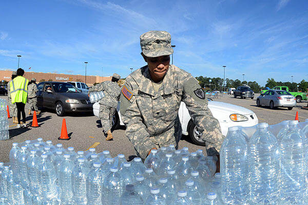 Army National Guardsmen distribute drinking water to residents affected by heavy rainfall caused by Hurricane Joaquin at the Lower Richland High School, Columbia, S.C., Oct. 6, 2015. (SC Air National Guard/A1C Ashleigh S. Pavelek)