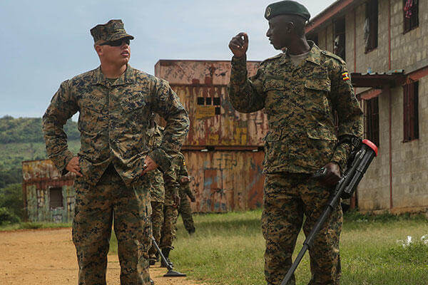 Sgt. Sean O’Hair, a combat engineer with Special-Purpose Marine Air-Ground Task Force Crisis Response-Africa, helps a member of the Uganda People’s Defense Force through an IED awareness exercise. (U.S. Marine Corps/Cpl. Olivia McDonald)