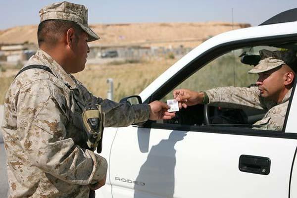 Marine checks ID at at Al Asad Air Base, Iraq. (Photo: Cpl. Daniel Redding, U.S. Marines)