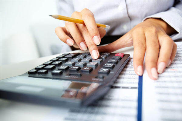 Businesswoman using a calculator and pencil.