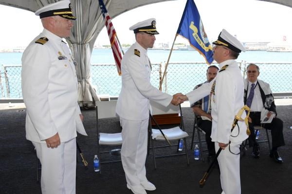 Capt. Howard Goldman, right, is congratulated by the commanding officer of the Submarine Learning Center as he relinquishes command of Naval Submarine Training Center Pacific during an Aug. 15, 2014, change of command ceremony. (Photo by Jason Swink/Navy)