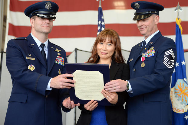 Mrs. Hyun Crites, wife of Chief Master Sgt. James Crites, 9th Operations Group superintendent (right), is presented the Military Spouse Medal during her husband’s retirement ceremony. (Photo: U.S. Air Force photo /Senior Airman Bobby Cummings.)