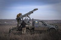 Ukrainian soldiers prepare to fire a multiple launch rocket system