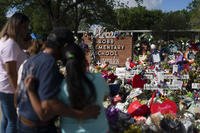 People visit a memorial at Robb Elementary School in Uvalde, Texas