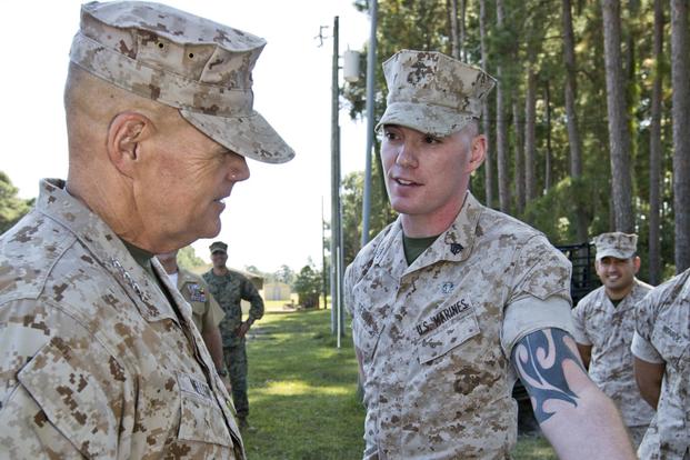 Commandant of the Marine Corps Gen. Robert B. Neller looks at a Marine's tattoo at Marine Corps Recruit Depot Parris Island, S.C., Oct. 16, 2015. (U.S. Marine Corps/Sgt. Gabriela Garcia)