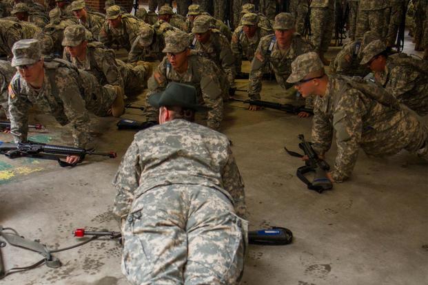 U.S. Army Drill Sgt. Angela Lee, who is with the 98th Training Division (IET), does pushups with her platoon during white phase of basic combat training at Fort Jackson, S.C., March 14, 2015. (U.S. Army photo by Sgt. Ken Scar)