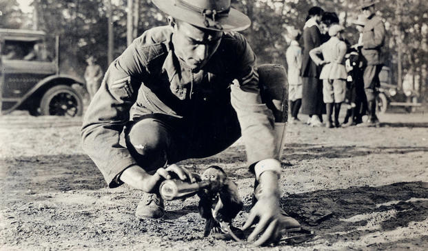 A World War I soldier plays with the unit mascot at Camp Wadsworth near Spartansburg, South Carolina. (Photo: National Archives and Records Administration)