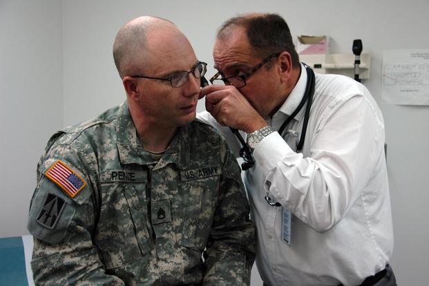 Staff Sgt. James Pence, a squad leader for 76th Brigade Combat Team, gets his ear checked by Dr. Tom Maibenco M.D., at the Camp Atterbury Troop Medical Clinic for a follow-up to an injury received while deployed in Iraq. (U.S. Army/Sgt. Elizabeth Houx)